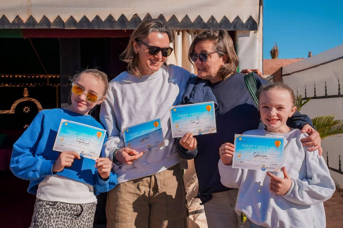 Family holding their balloon flight certificates after landing