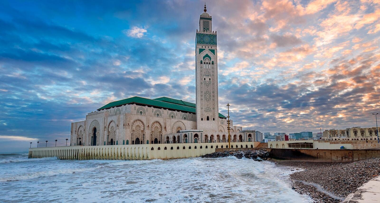 Hassan II Mosque and its minaret at sunset, with Atlantic waves breaking in front