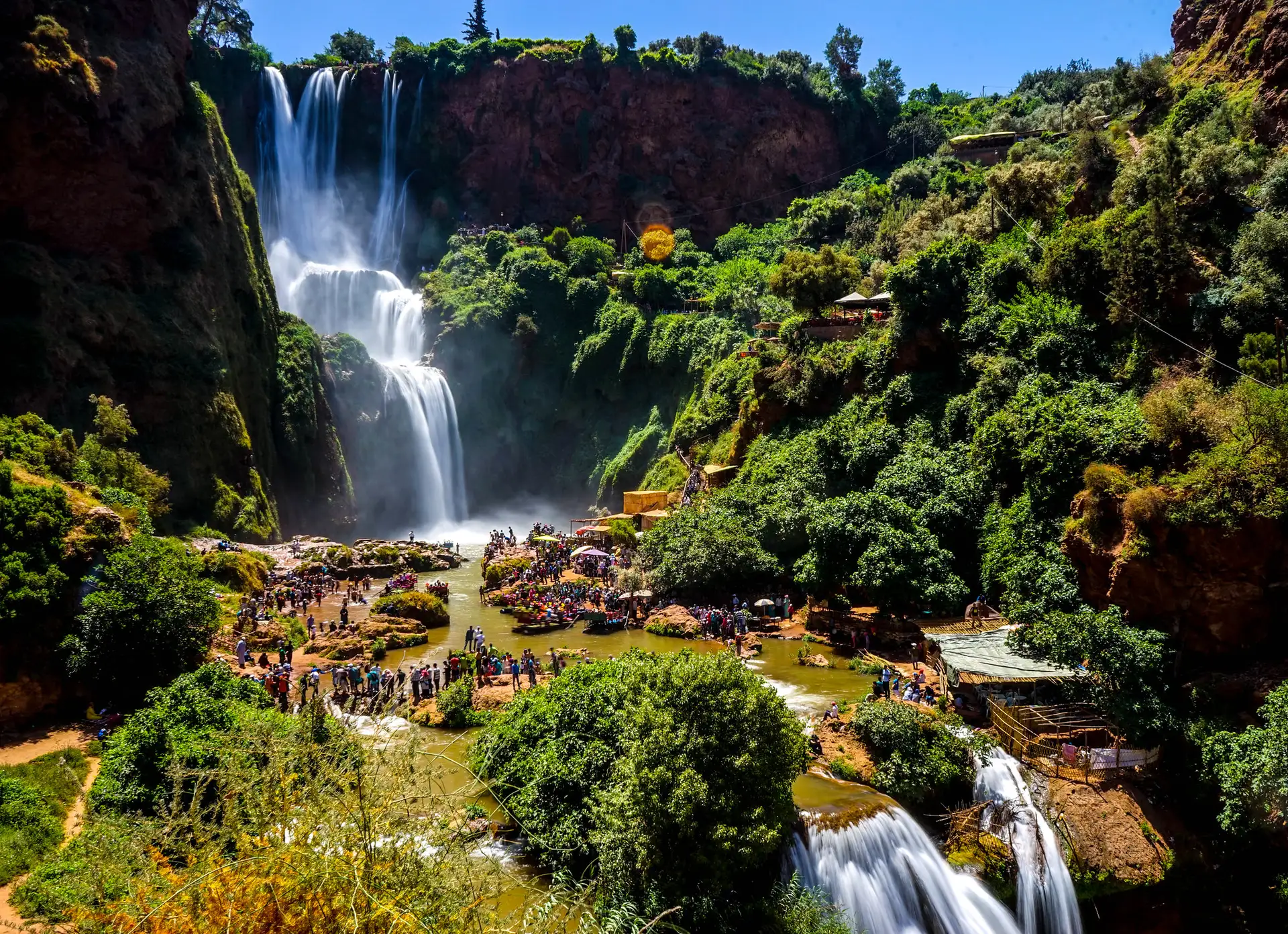 The Ouzoud Waterfalls with visitors gathered at the river below