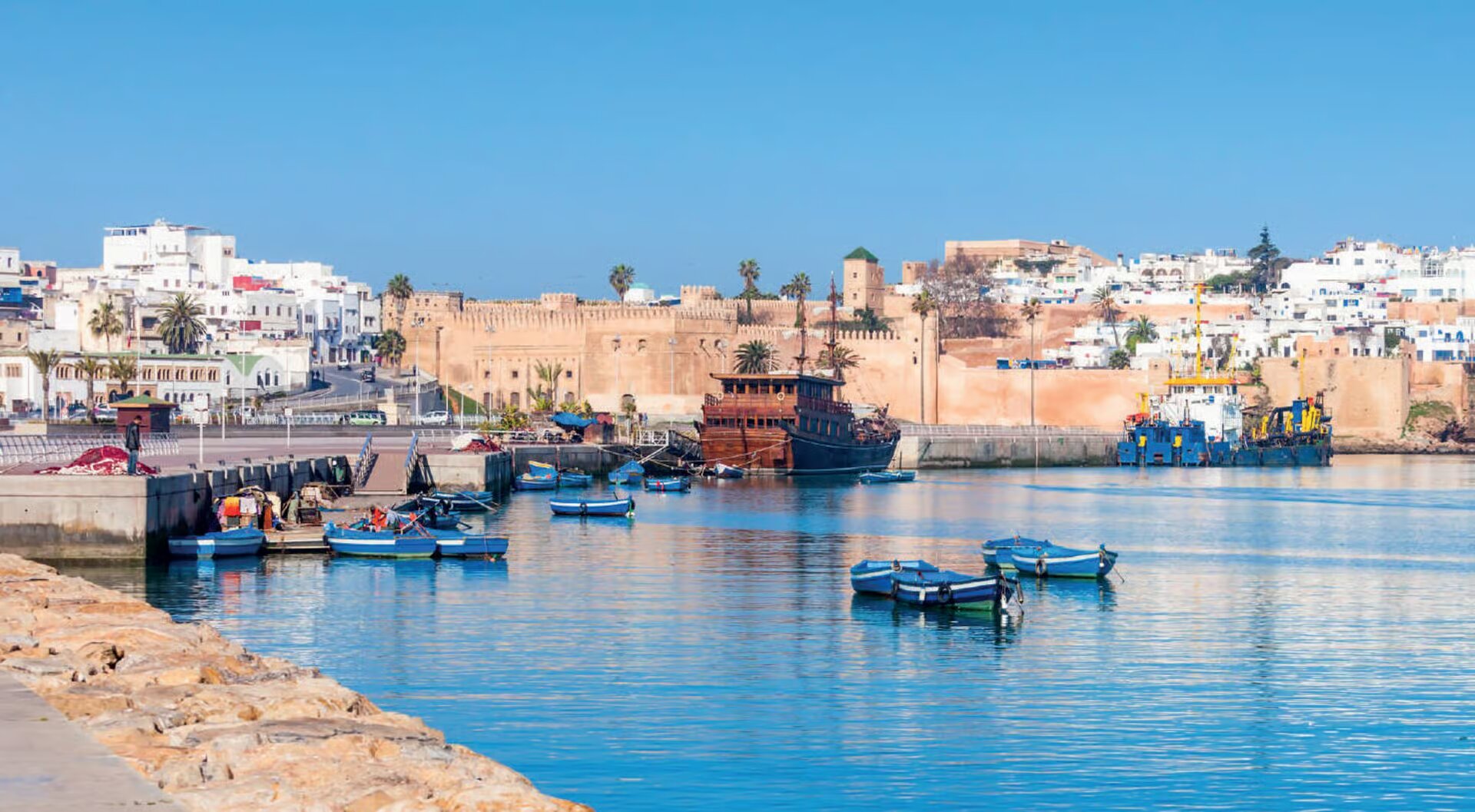 Boats on the calm Bouregreg River in front of Rabat's old city walls